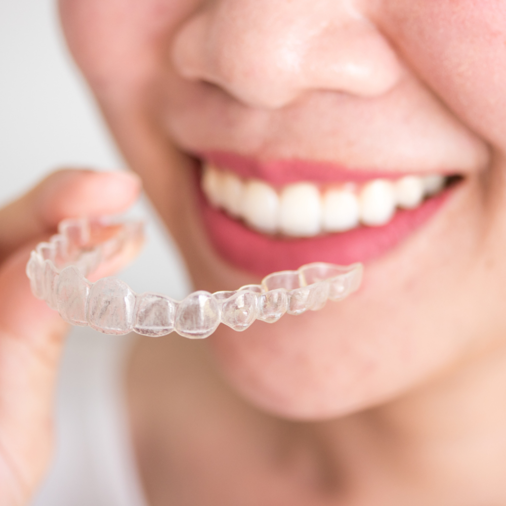 invisalign held by a smiling woman
